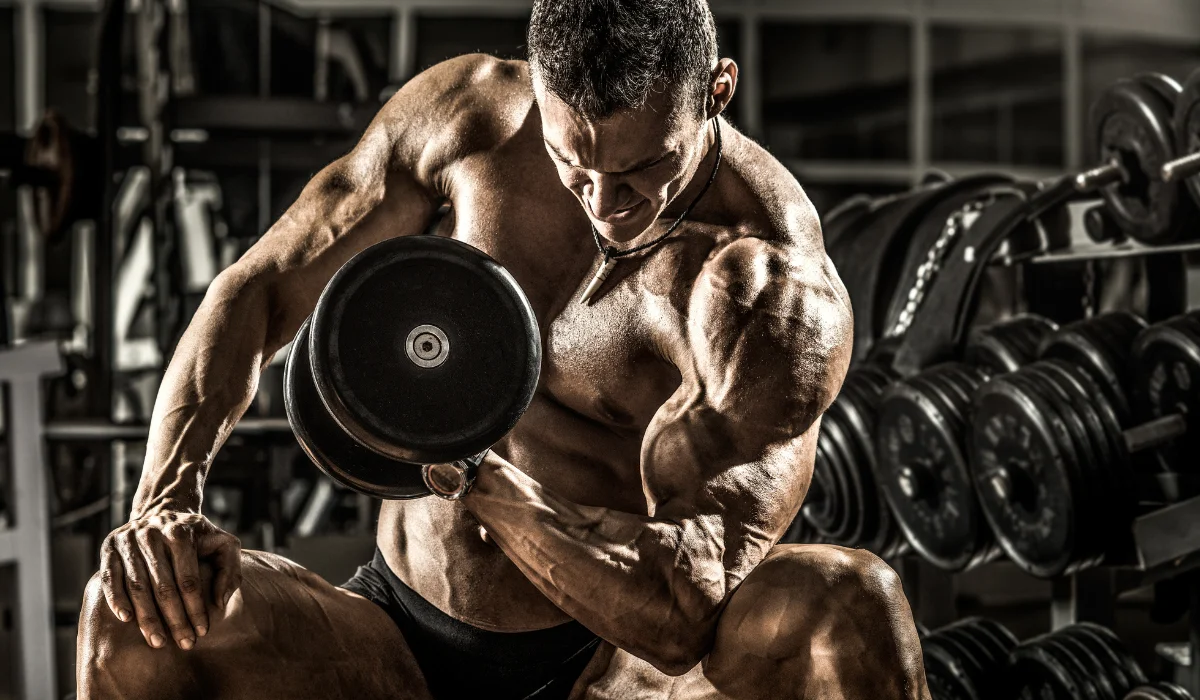 Muscular man working out with dumbbell